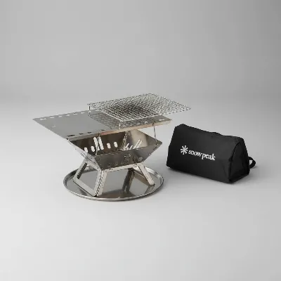 Snow Peak Takibi Fire and Grill modular components laid out, stainless steel parts gleaming, ready for assembly.