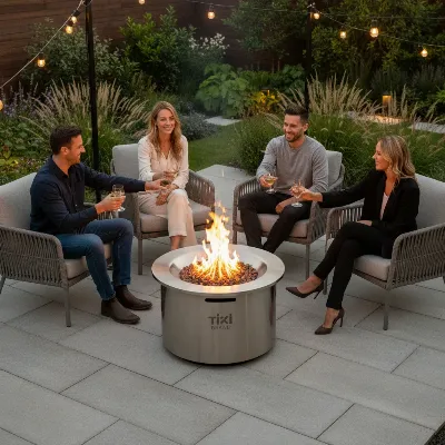 A TIKI Brand smokeless fire pit glowing brightly on a modern patio at dusk, surrounded by comfortable seating with friends gathered enjoying the warmth and ambiance, minimal smoke rising straight up.